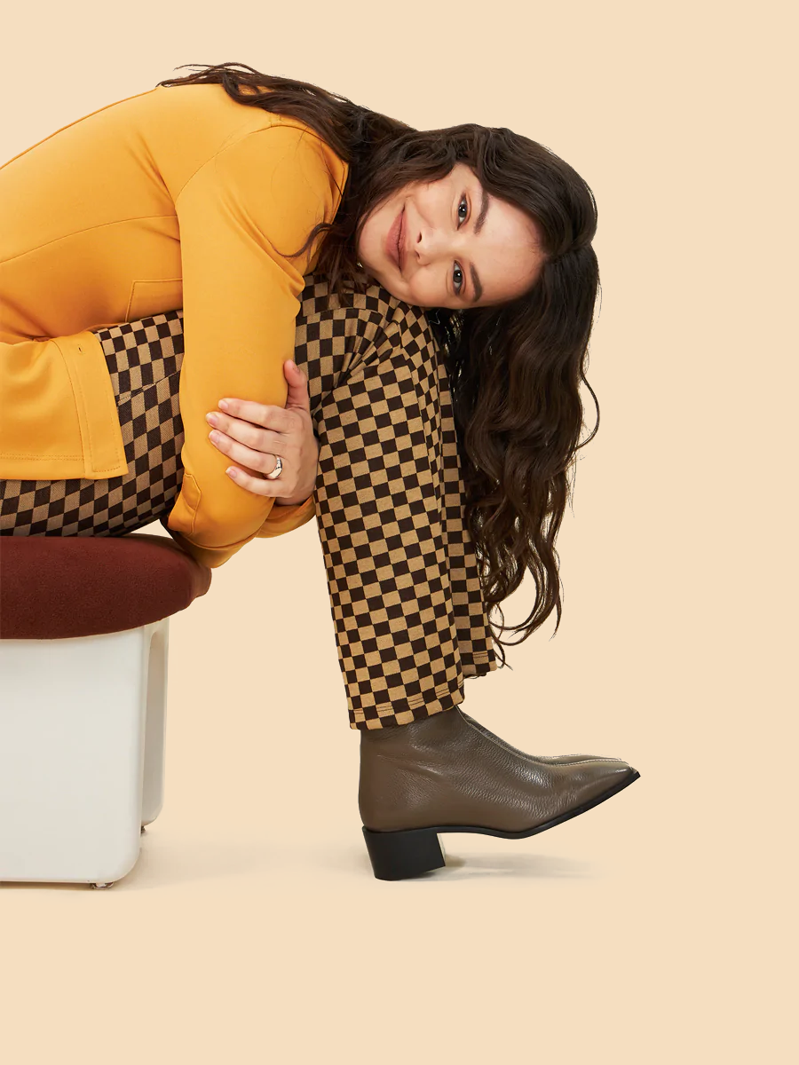 A woman dressed in yellow wearing brown leather boots