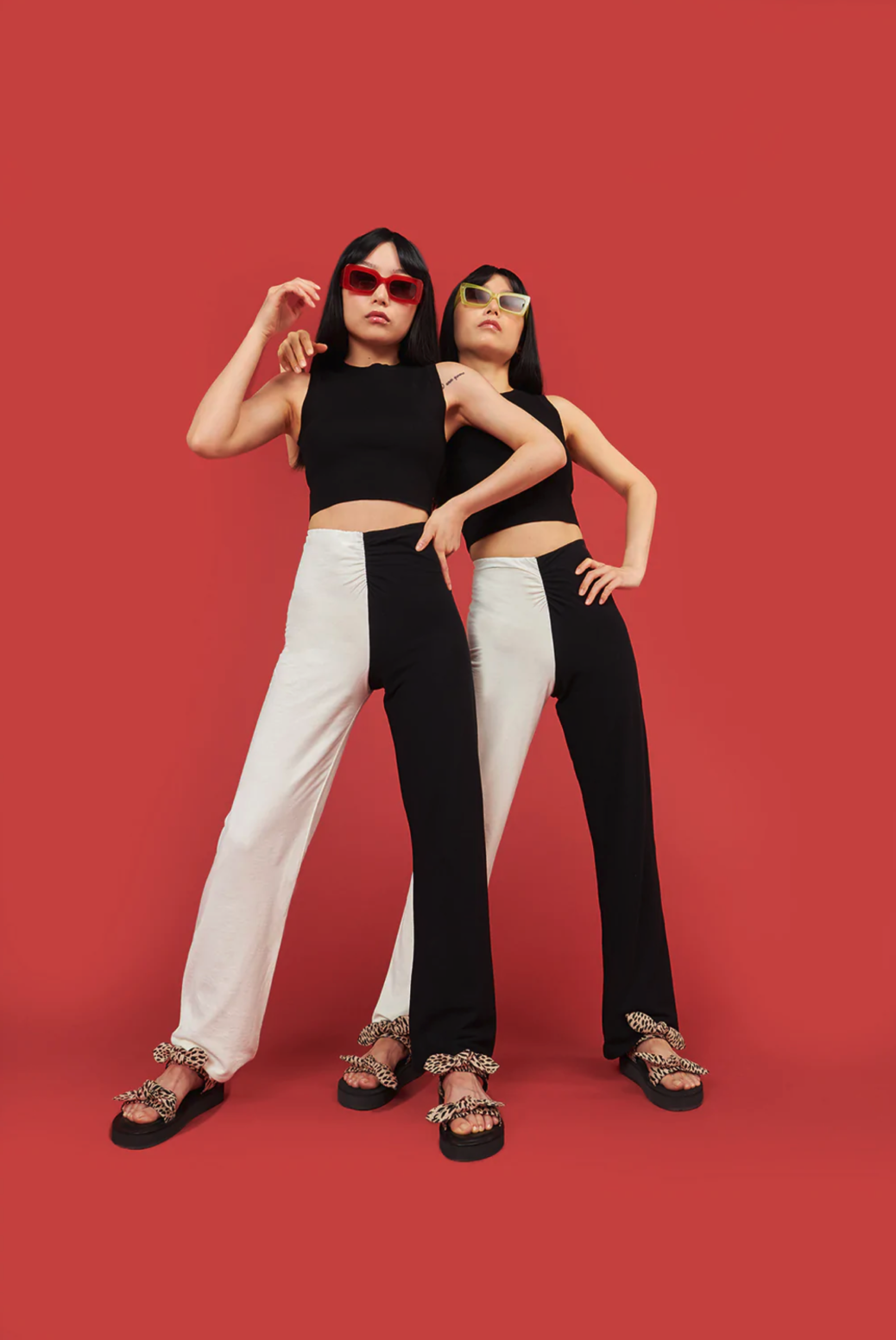 Two women dressed in black and white wearing sandals.
