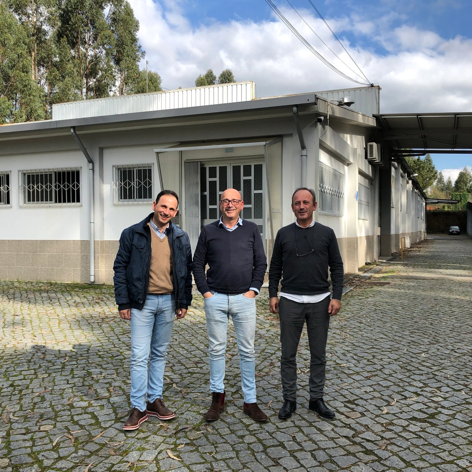 Three brothers posing in front of their family-owned factory in Fornos, Portugal