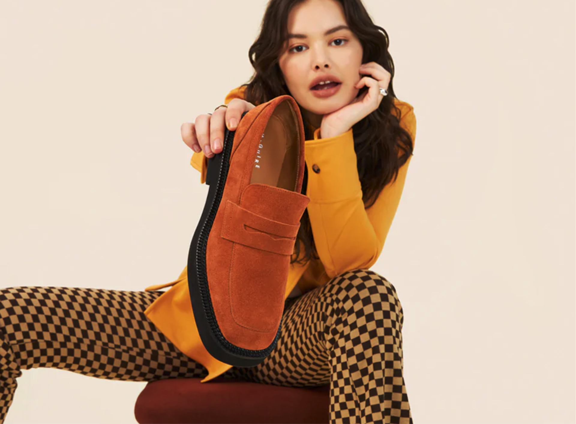 A woman holding the brown Valencia shoe.